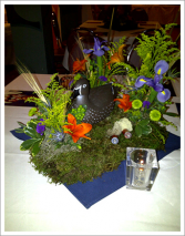 Candle near floral arrangement